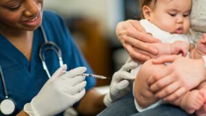 Vårdpersonal ger en vaccination till en baby i en klinisk miljö.